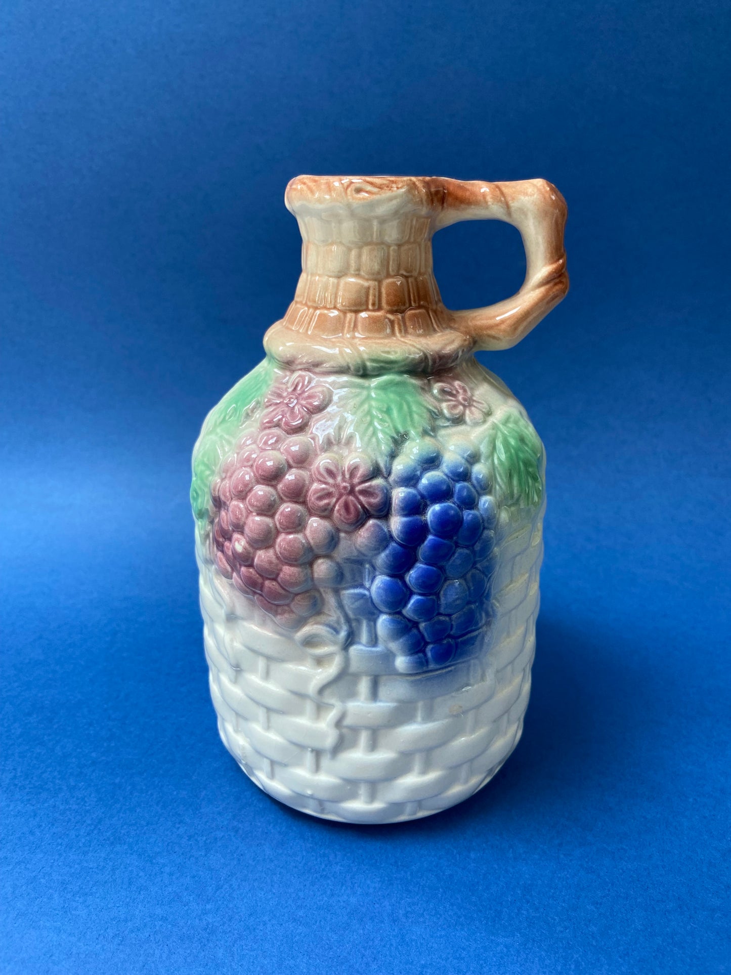 Wine pitcher with woven basket and grapes decor