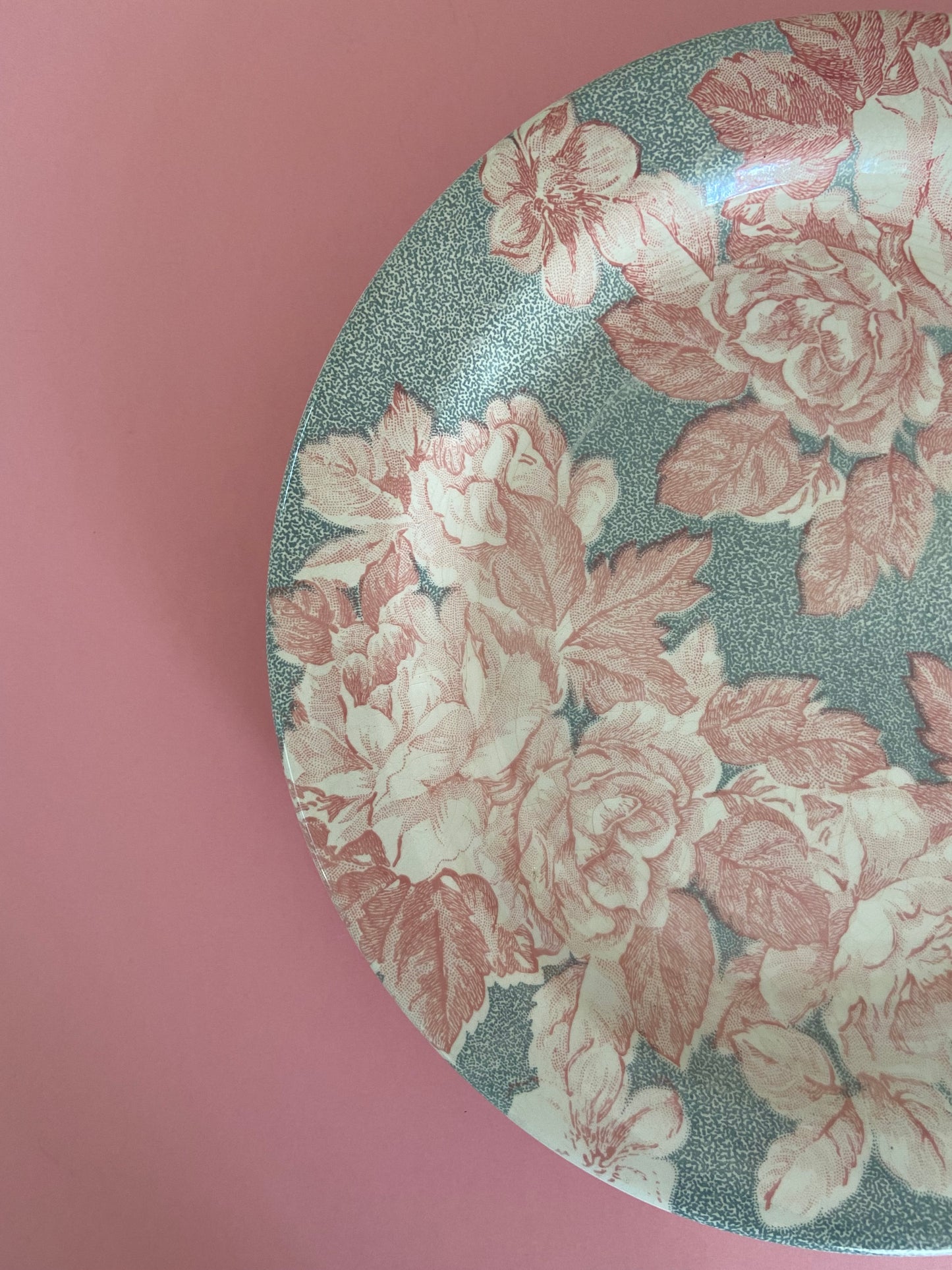 Flat plate with pink floral decoration on a gray background made in Italy