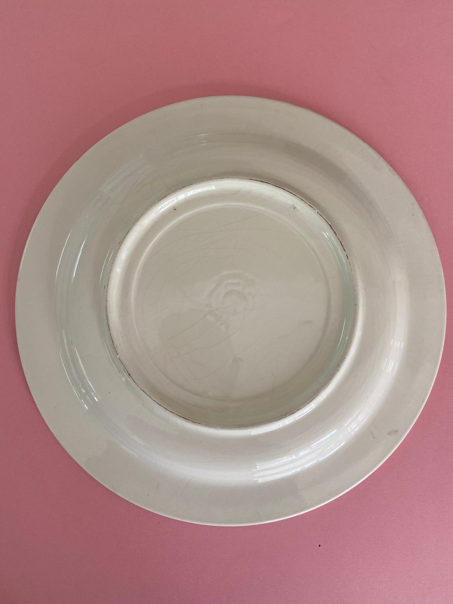 Flat plate with pink floral decoration on a gray background made in Italy