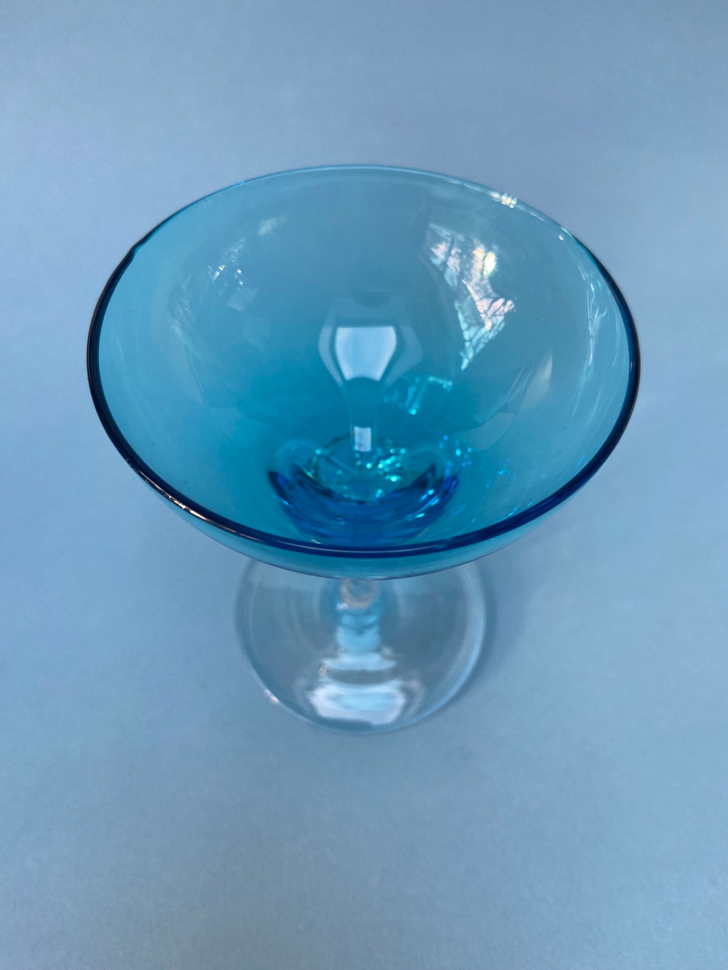 Transparent twisted foot cocktail glass and blue glass